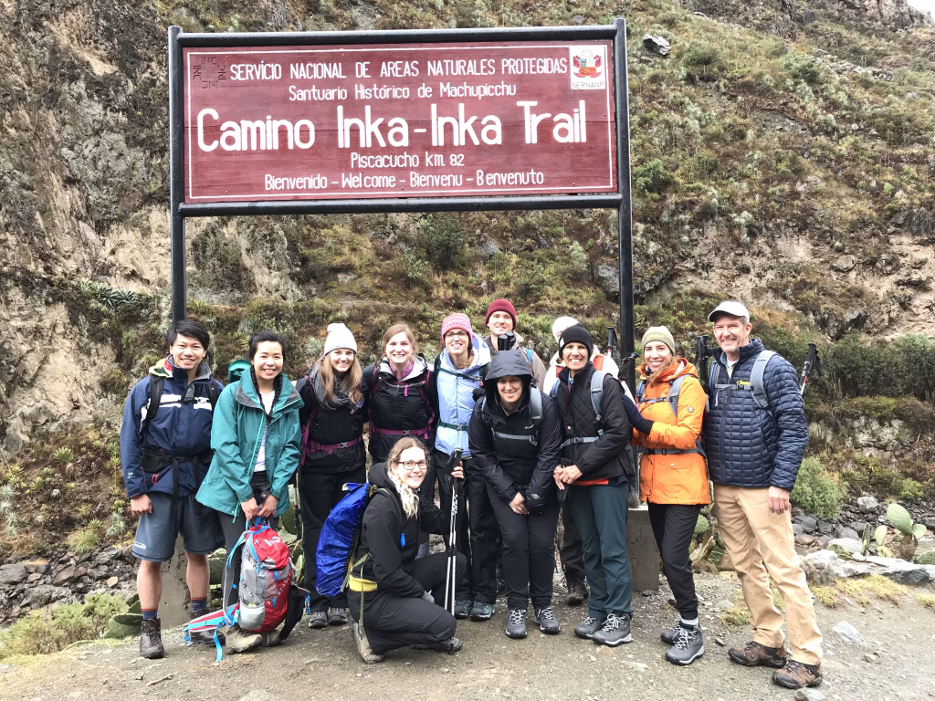 Hikers walking on the ancient Classic Inca Trail stone path to Machu Picchu.