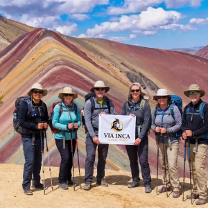 A hiker standing at the 5,036m summit of the 7-color Rainbow Mountain.